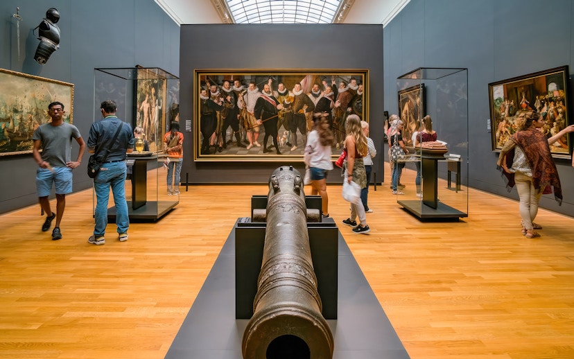 Visitors exploring art and artifacts in a gallery during the First Access Guided Tour of Rijksmuseum.
