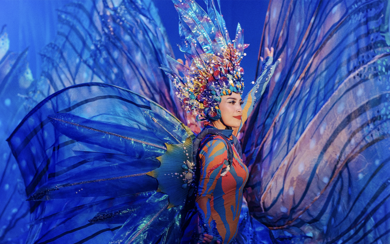 Performer in vibrant costume at Varuna Underwater Show, Bali Safari & Marine Park.
