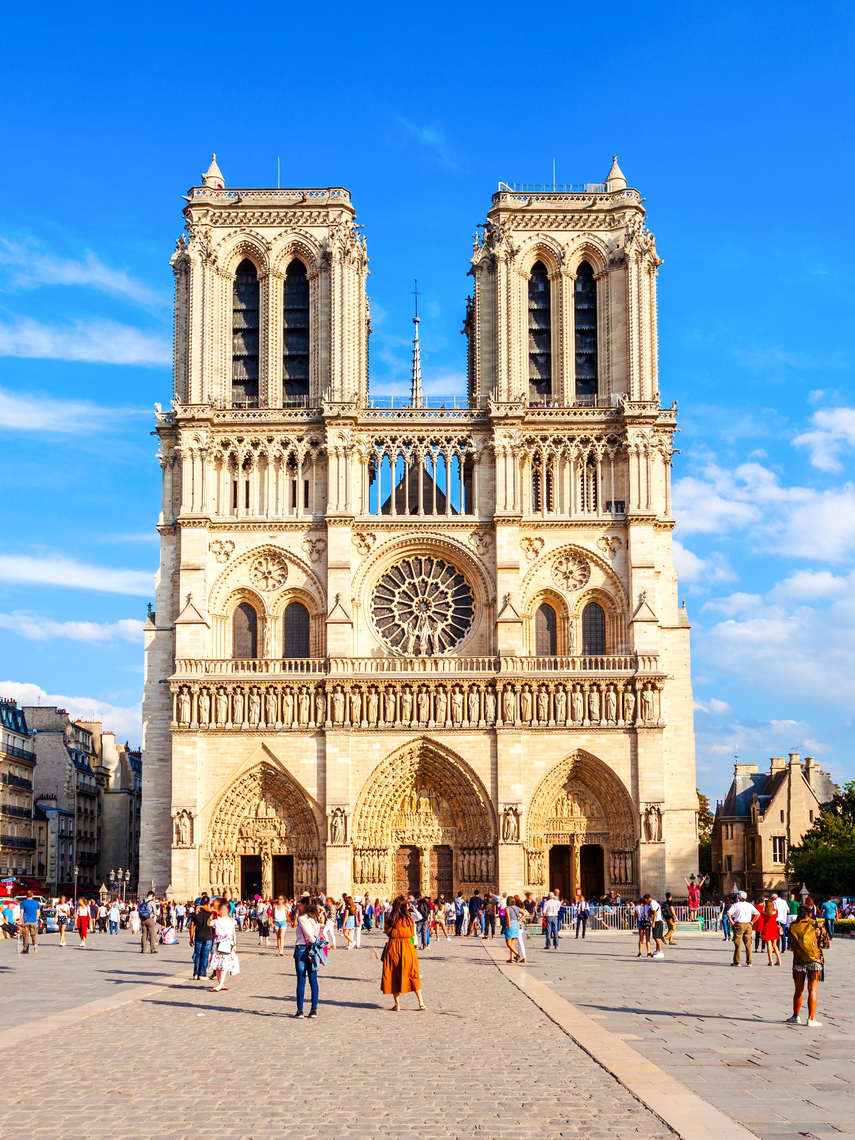 Notre Dame Cathedral facade with visitors in Paris, France.