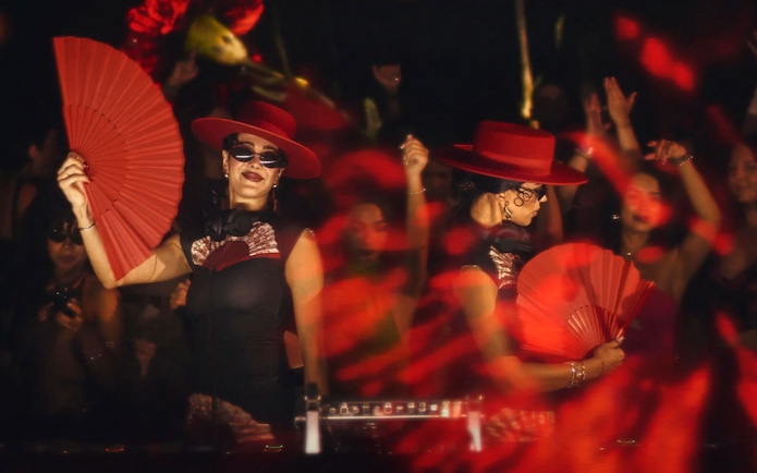 Dancers with red fans and hats performing at Mestiza, Ibiza nightclub.