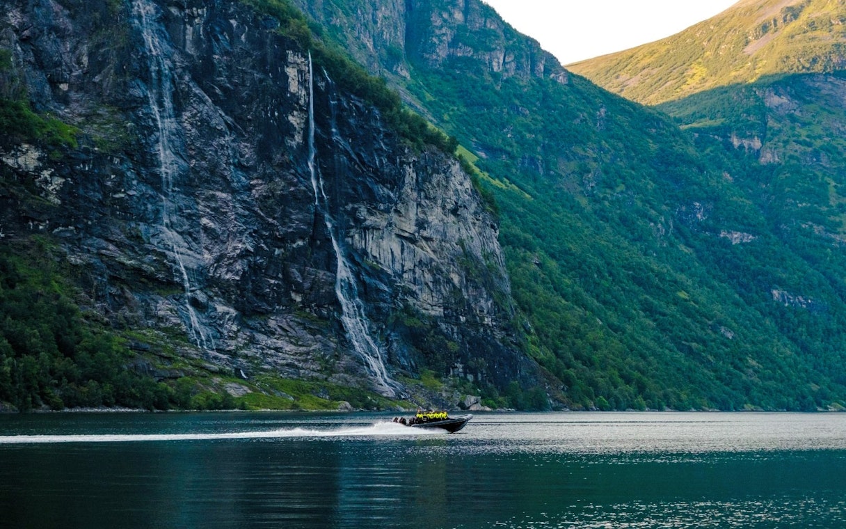 RIB boat on Geirangerfjord near Hellesylt waterfall, Norway.