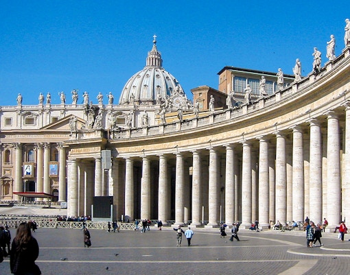 Tourists in St. Peter's Square with St. Peter's Basilica, Vatican City.