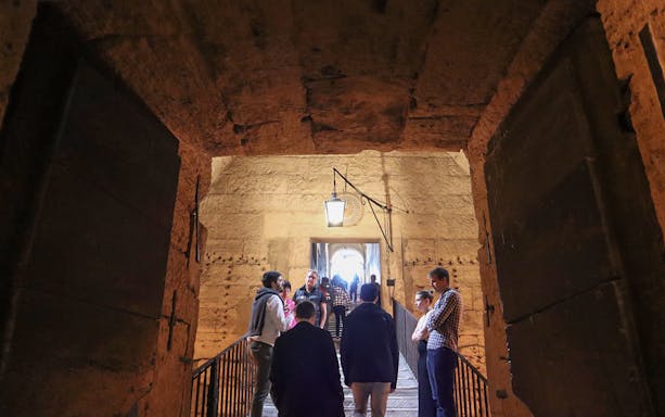 Visitors exploring the interior passage of Castel Sant'Angelo in Rome.