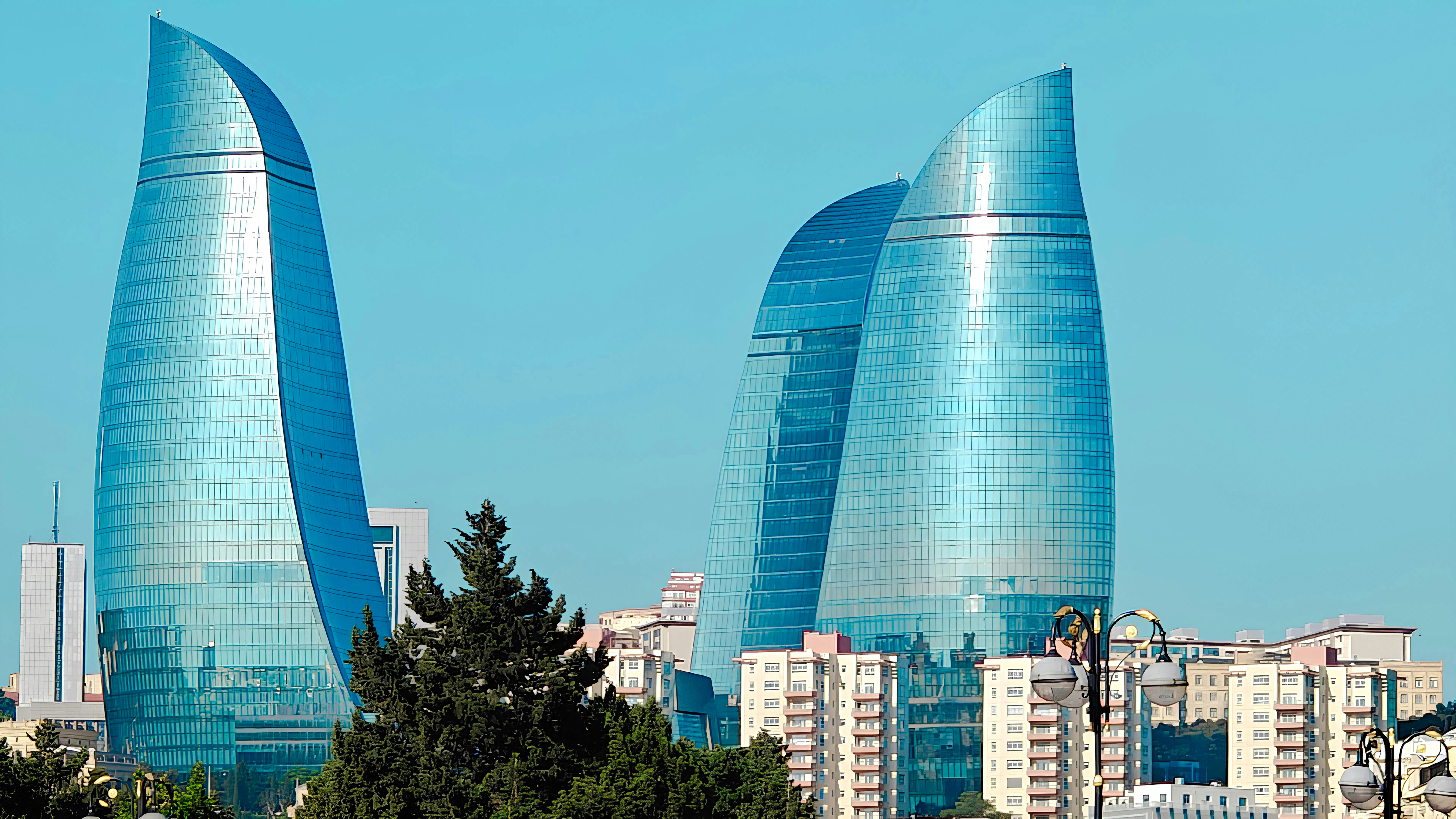 Flame Towers in Baku, Azerbaijan, with modern architecture against a clear sky.
