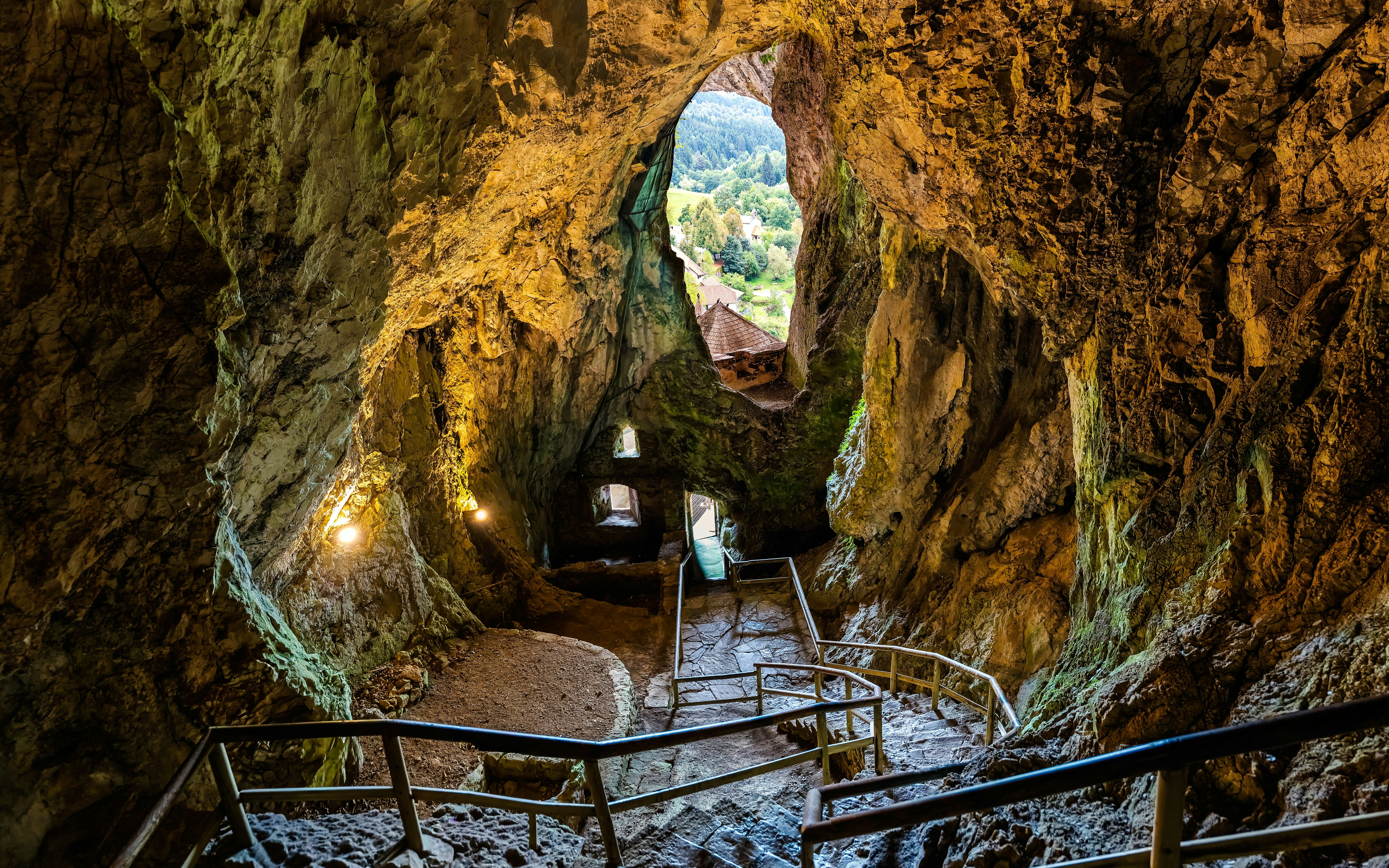 Interior view of Predjama Castle cave with stone steps and natural rock formations.