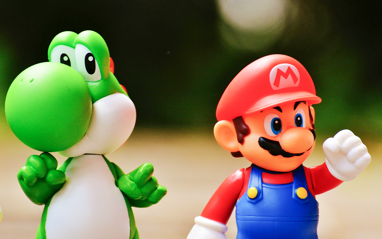 Super Mario and Yoshi figurines standing together.