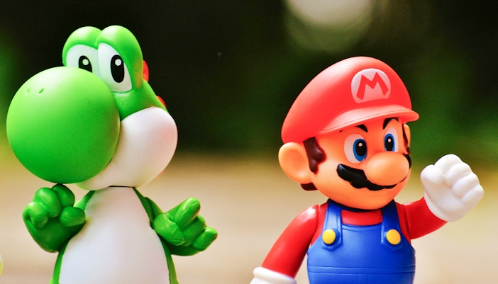 Super Mario and Yoshi figurines standing together.