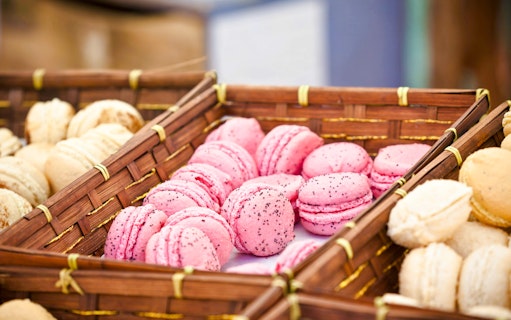 Pink and beige macarons in a basket, Parisian tea time theme.