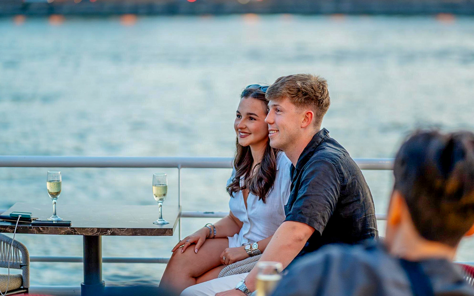 Guests enjoying drinks on Budapest Danube River nighttime cruise.