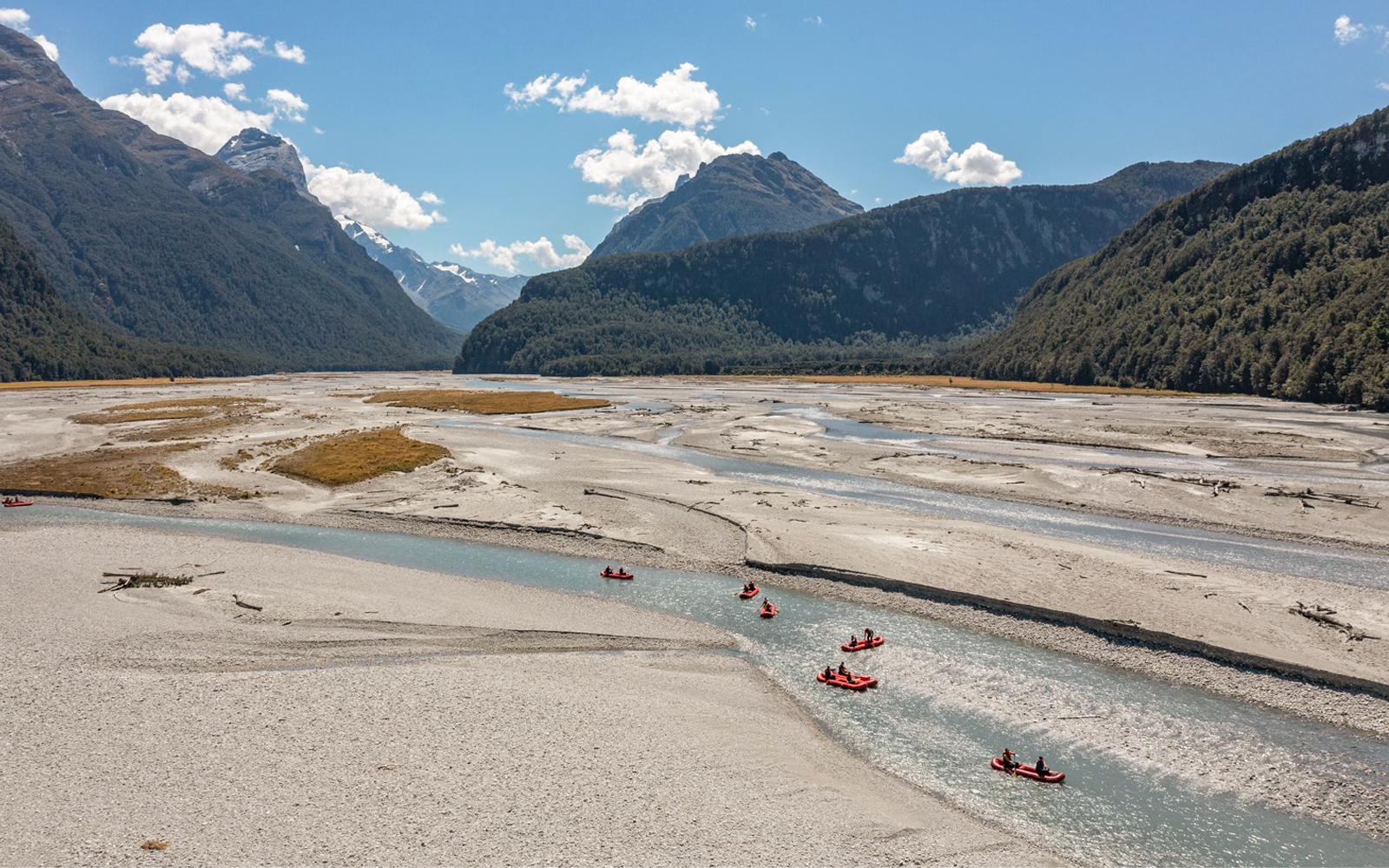 Funyaks on Dart River with mountain backdrop in New Zealand.
