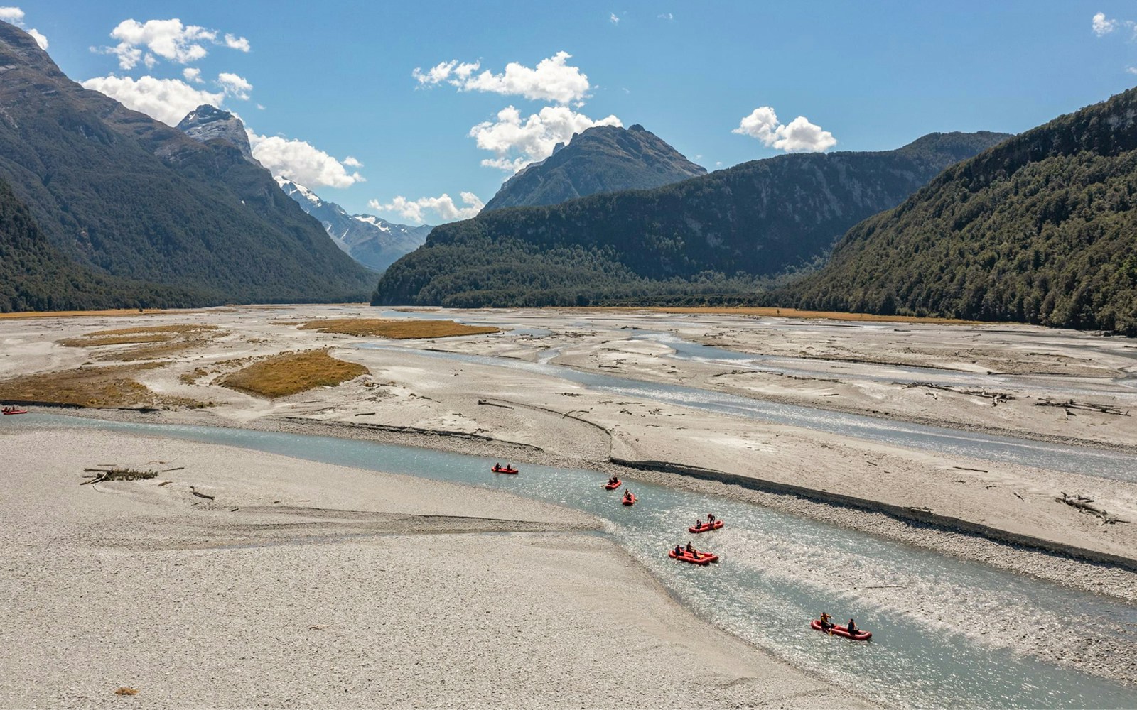 Funyaks on Dart River with mountain backdrop in New Zealand.
