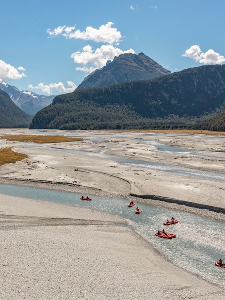 Funyaks on Dart River with mountain backdrop in New Zealand.