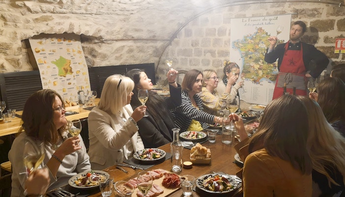 People enjoying a cheese and wine tasting at Paroles de Fromagers in Paris, France.
