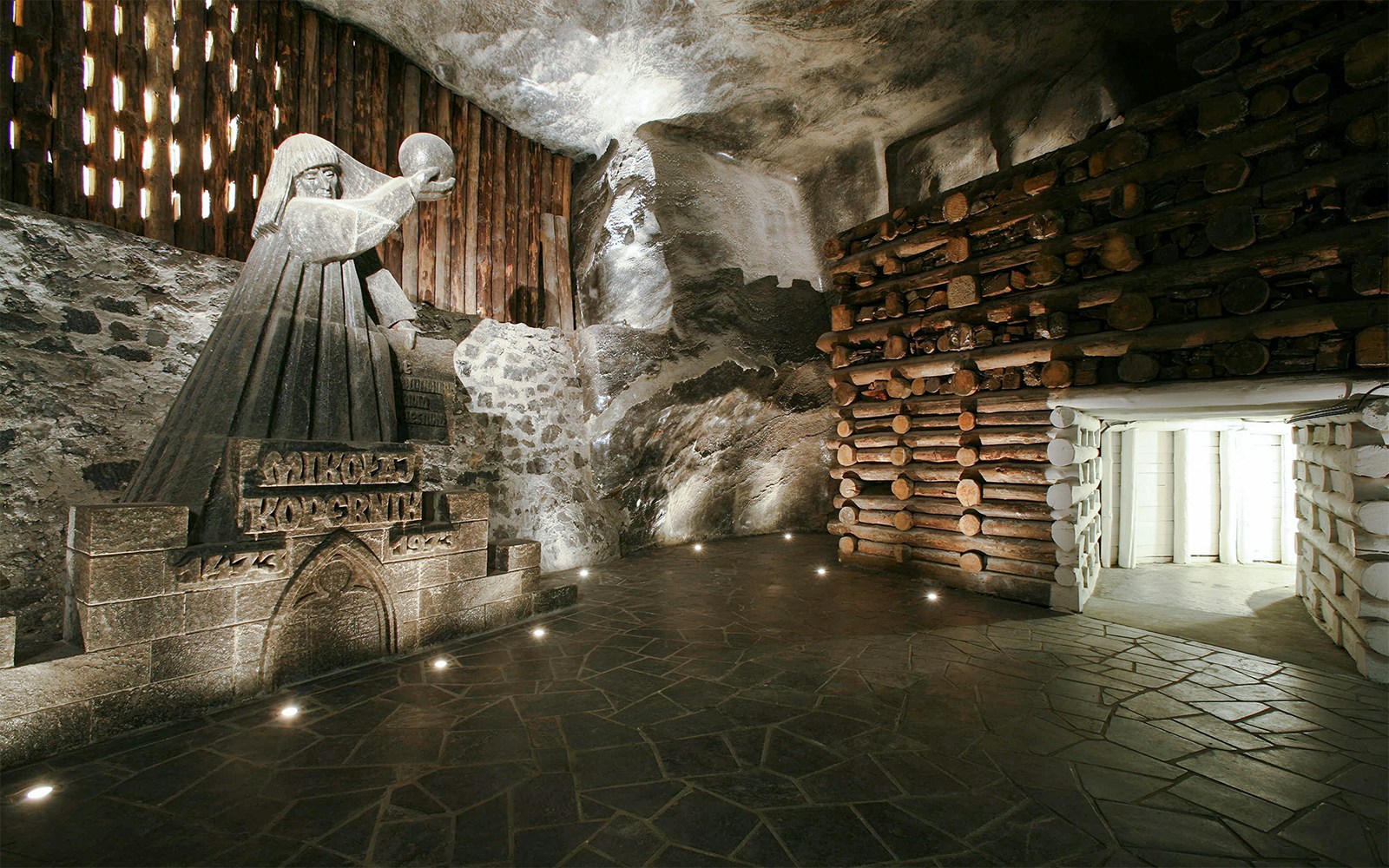 Wieliczka Salt Mine sculpture of a robed figure holding a sphere, surrounded by salt walls.