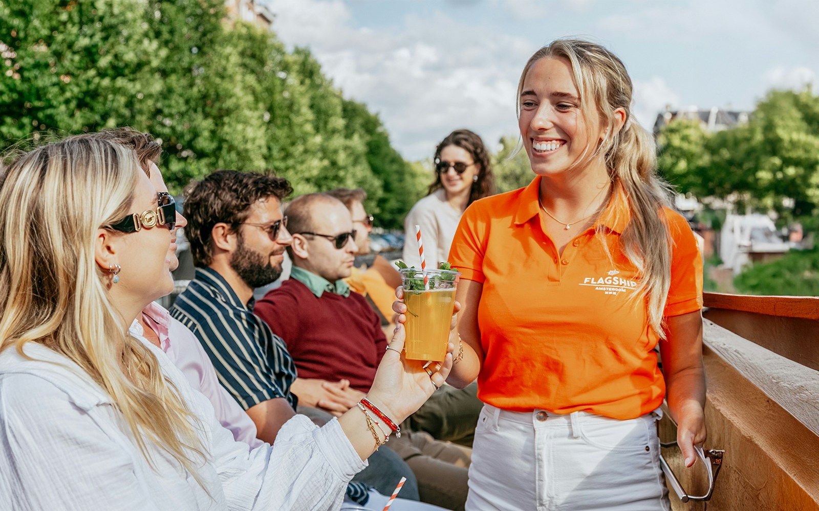 Amsterdam evening canal cruise with passengers enjoying views from a luxury boat with onboard bar.