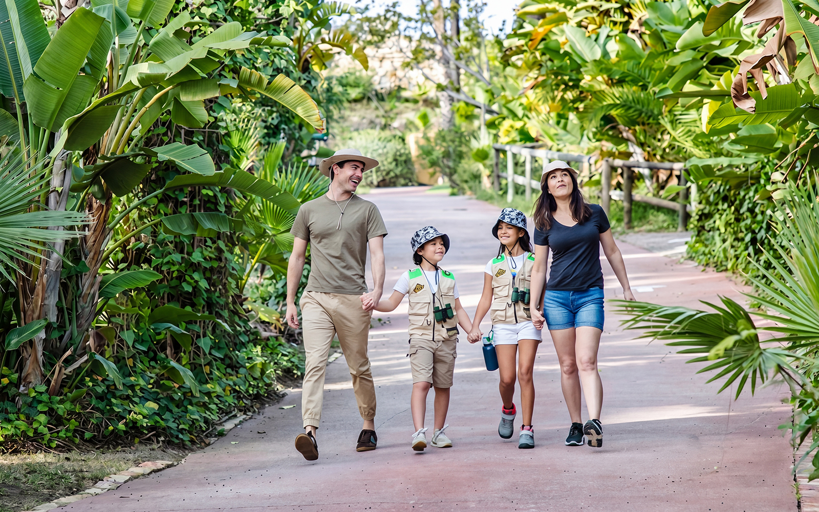 Family walking through lush greenery at Selwo Aventura park, Estepona, Spain.