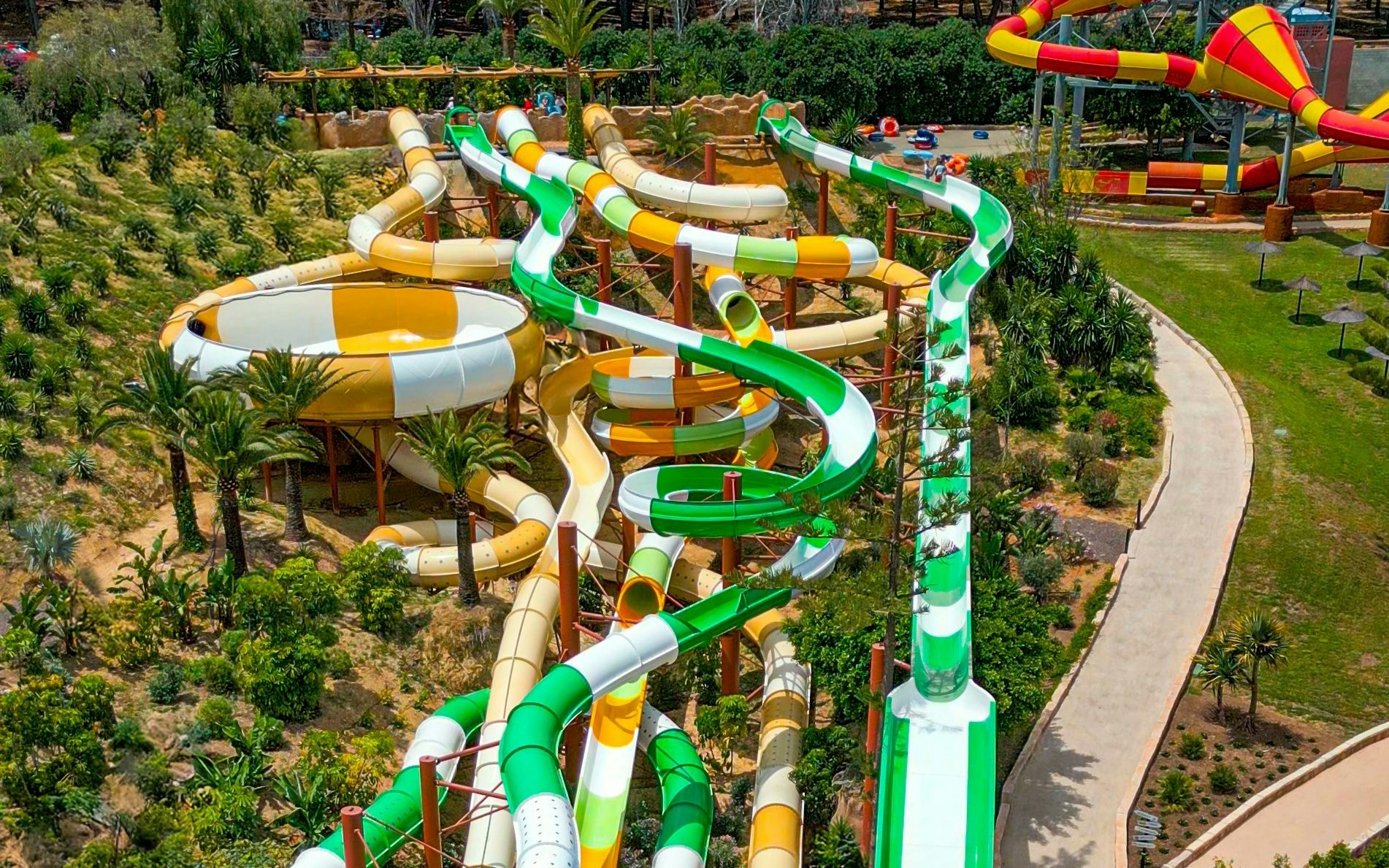 Hurakan water slide at Aqualand Torremolinos with winding green and yellow tubes.