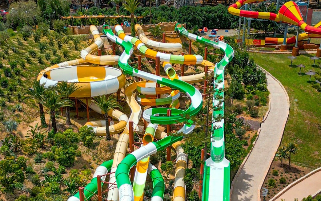 Hurakan water slide at Aqualand Torremolinos with winding green and yellow tubes.