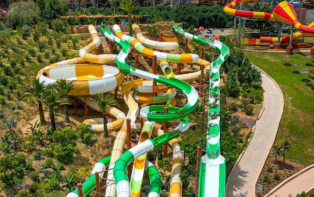 Hurakan water slide at Aqualand Torremolinos with winding green and yellow tubes.