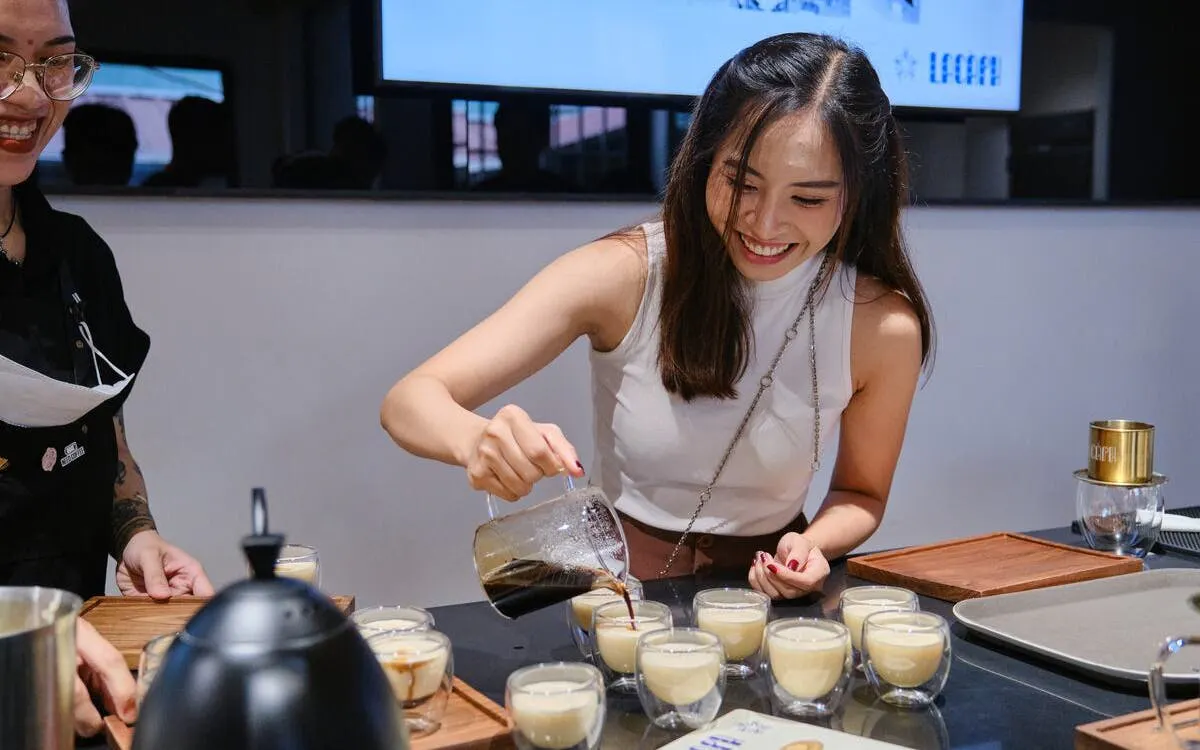 Pouring coffee into cups for Vietnamese egg coffee preparation.