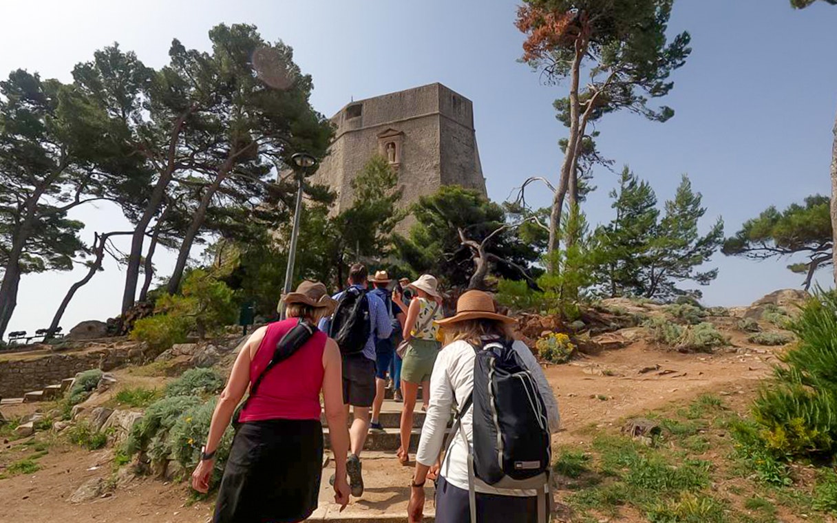 Guests walking towards a historic tower in Dubrovnik, Game of Thrones tour location.