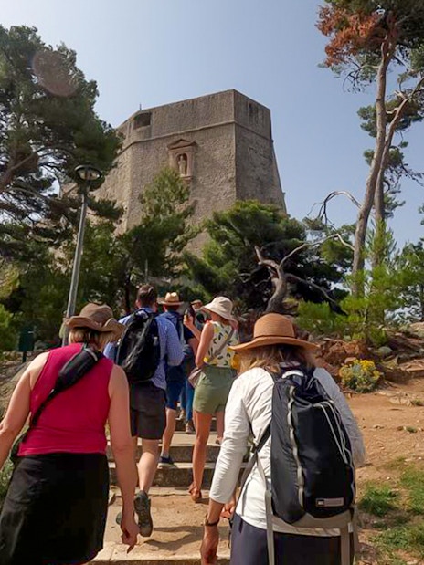 Guests walking towards a historic tower in Dubrovnik, Game of Thrones tour location.