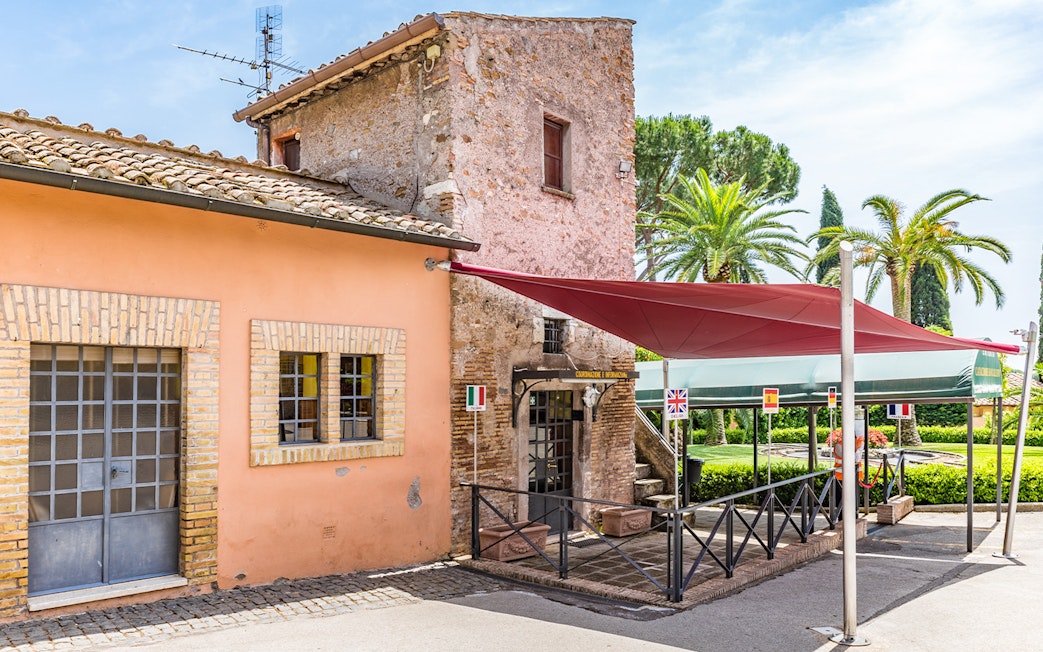 Entrance to the Catacomb of Callixtus on the Appian Way, Italy, with flags and canopy.