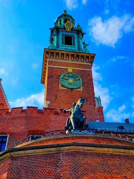 Wawel Castle tower with clock and equestrian statue in Krakow, Poland.