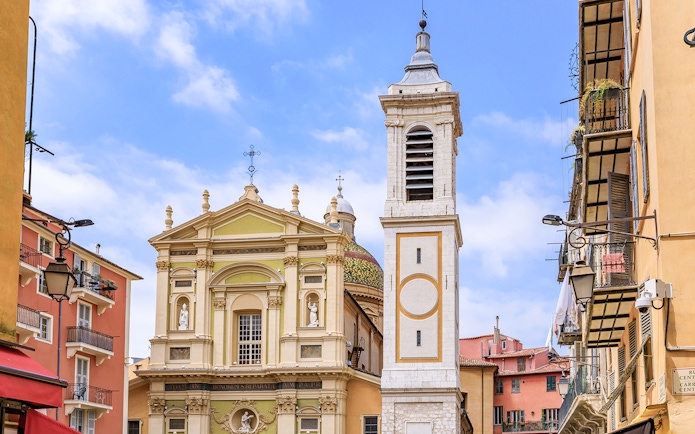 Saint Reparata Cathedral facade and bell tower in Nice, France, surrounded by colorful buildings.