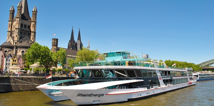 Cruise ship on the Rhine River with Cologne Cathedral in the background.
