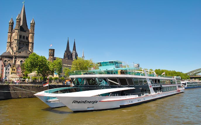 Cruise ship on the Rhine River with Cologne Cathedral in the background.