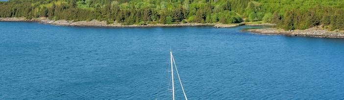 Sailing boat on Stavanger Fjord with scenic mountain backdrop, Norway.