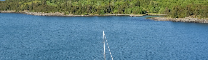 Sailing boat on Stavanger Fjord with scenic mountain backdrop, Norway.