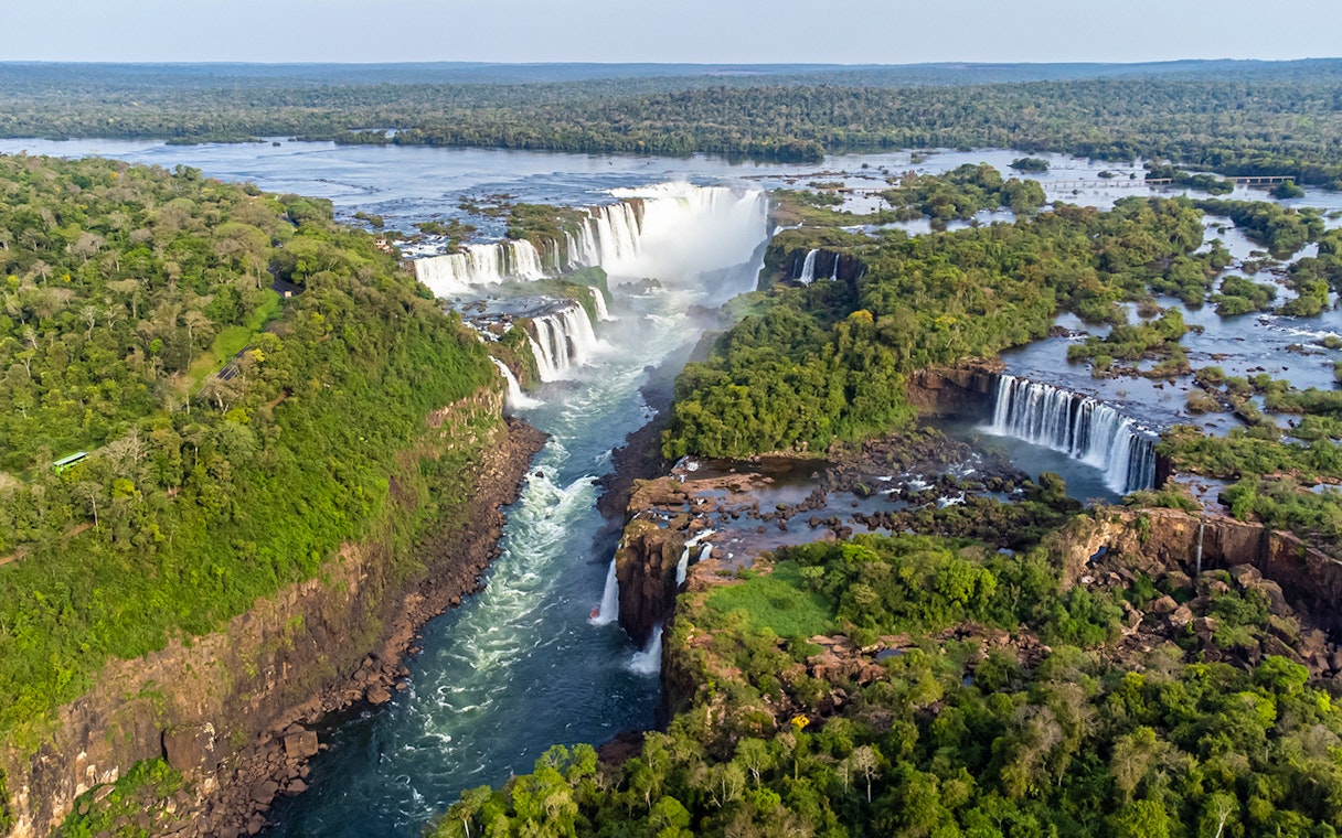 Aerial view of Iguazu Falls with lush greenery and cascading water.