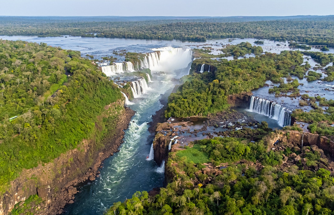 Aerial view of Iguazu Falls with lush greenery and cascading water.