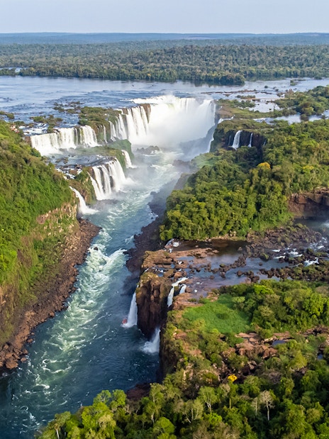 Aerial view of Iguazu Falls with lush greenery and cascading water.