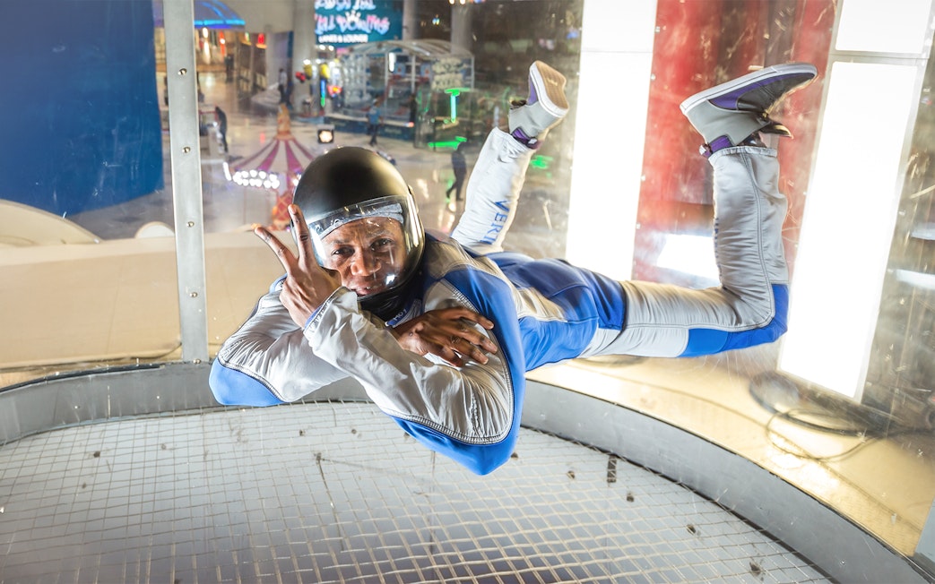 Instructor demonstrating iFly Dubai indoor skydive in wind tunnel.