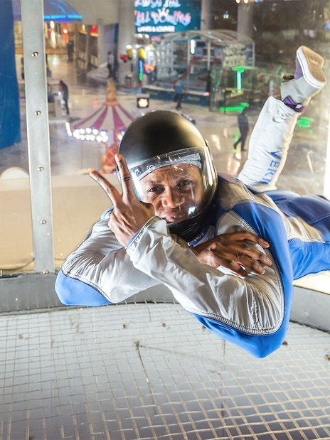 Instructor demonstrating iFly Dubai indoor skydive in wind tunnel.