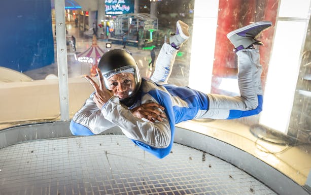 Instructor demonstrating iFly Dubai indoor skydive in wind tunnel.
