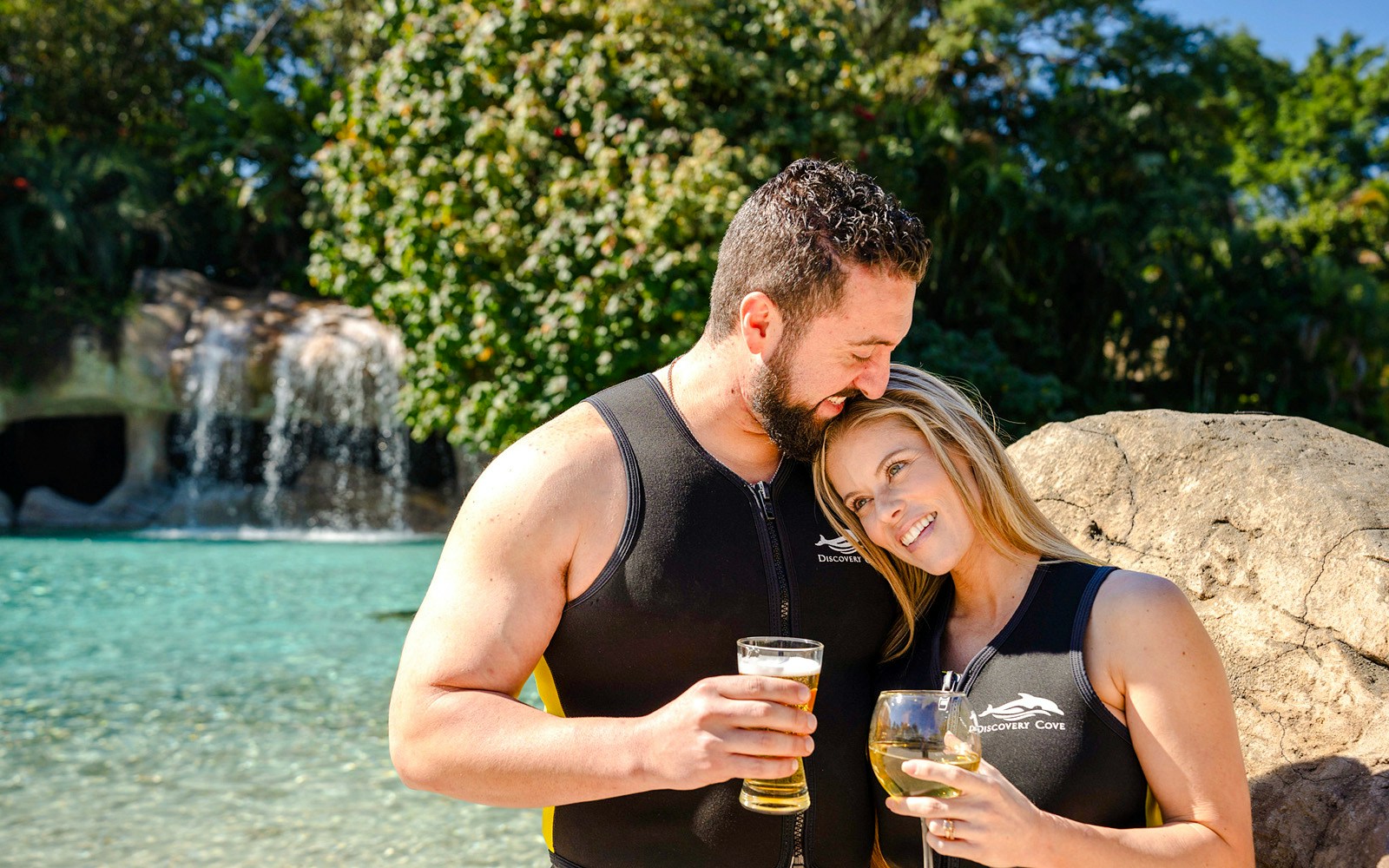Couple enjoying drinks by a waterfall at Discovery Cove Orlando.