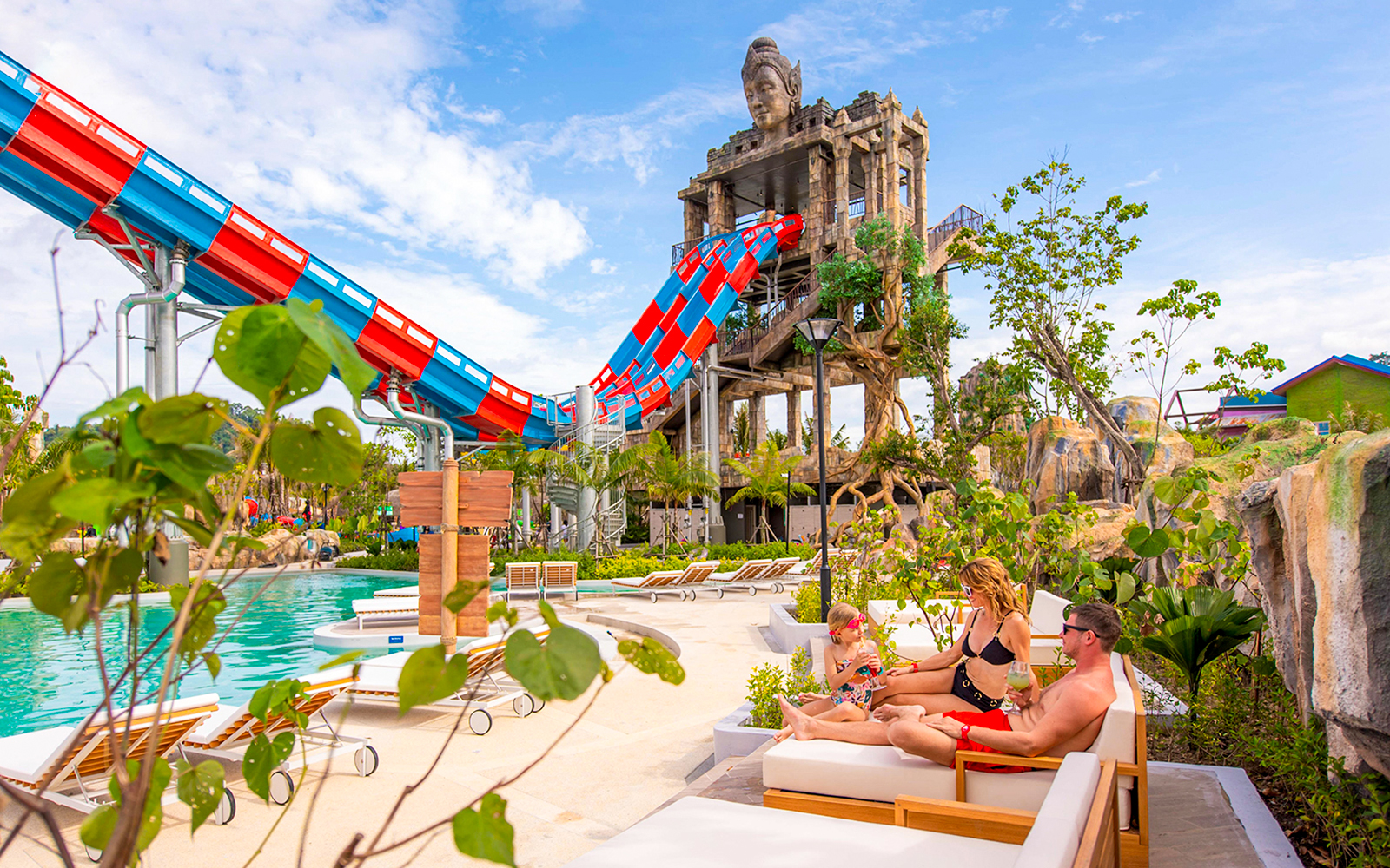 Family relaxing on deck chairs near the Emerald Forest ride at Andamanda Phuket.