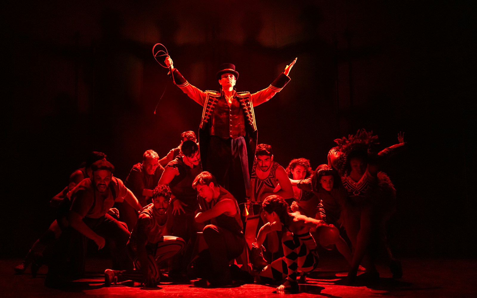 Circus performers in dramatic red lighting during a "Water for Elephants" show.