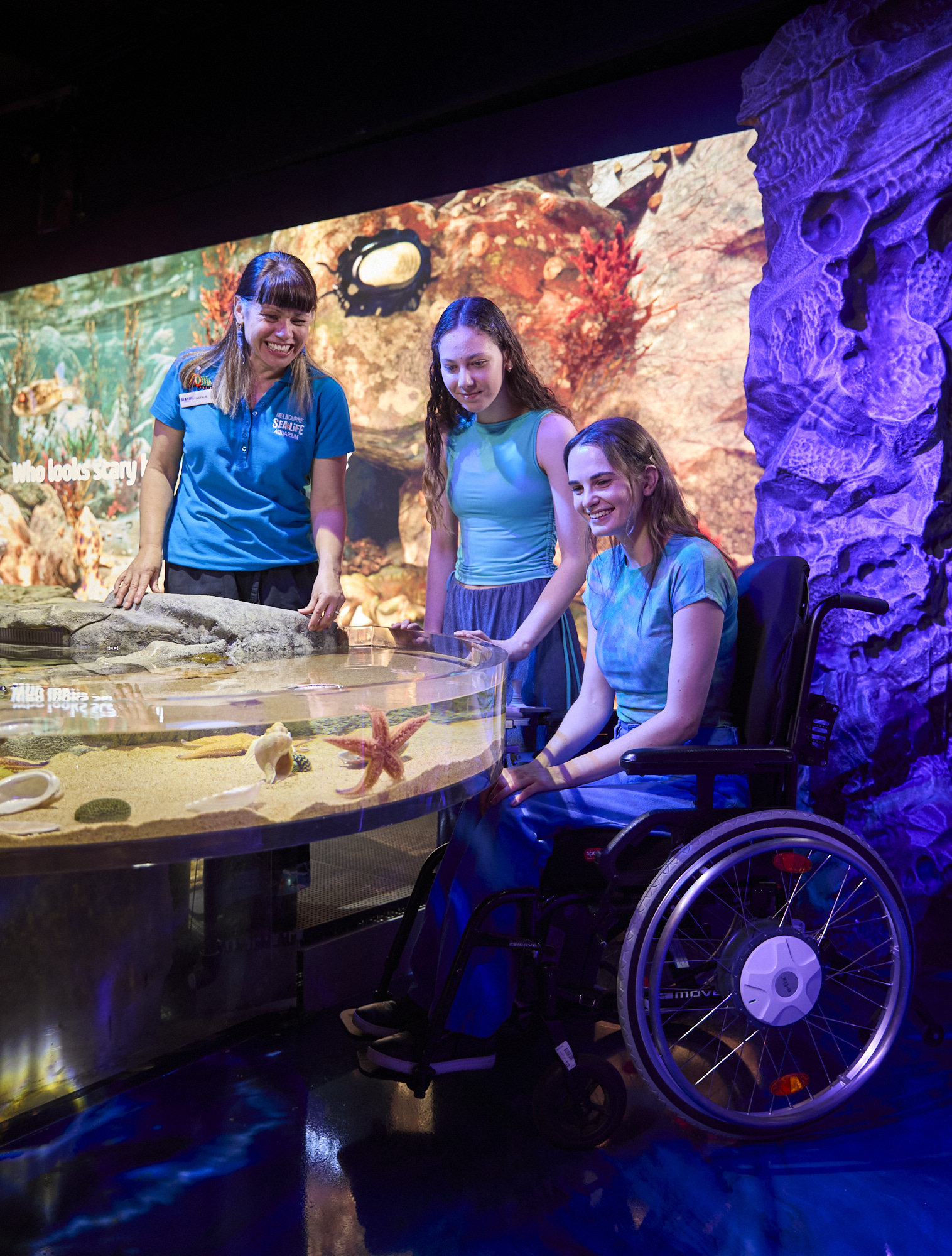 Wheelchair user interacting with a touch tank at Sea Life Melbourne.