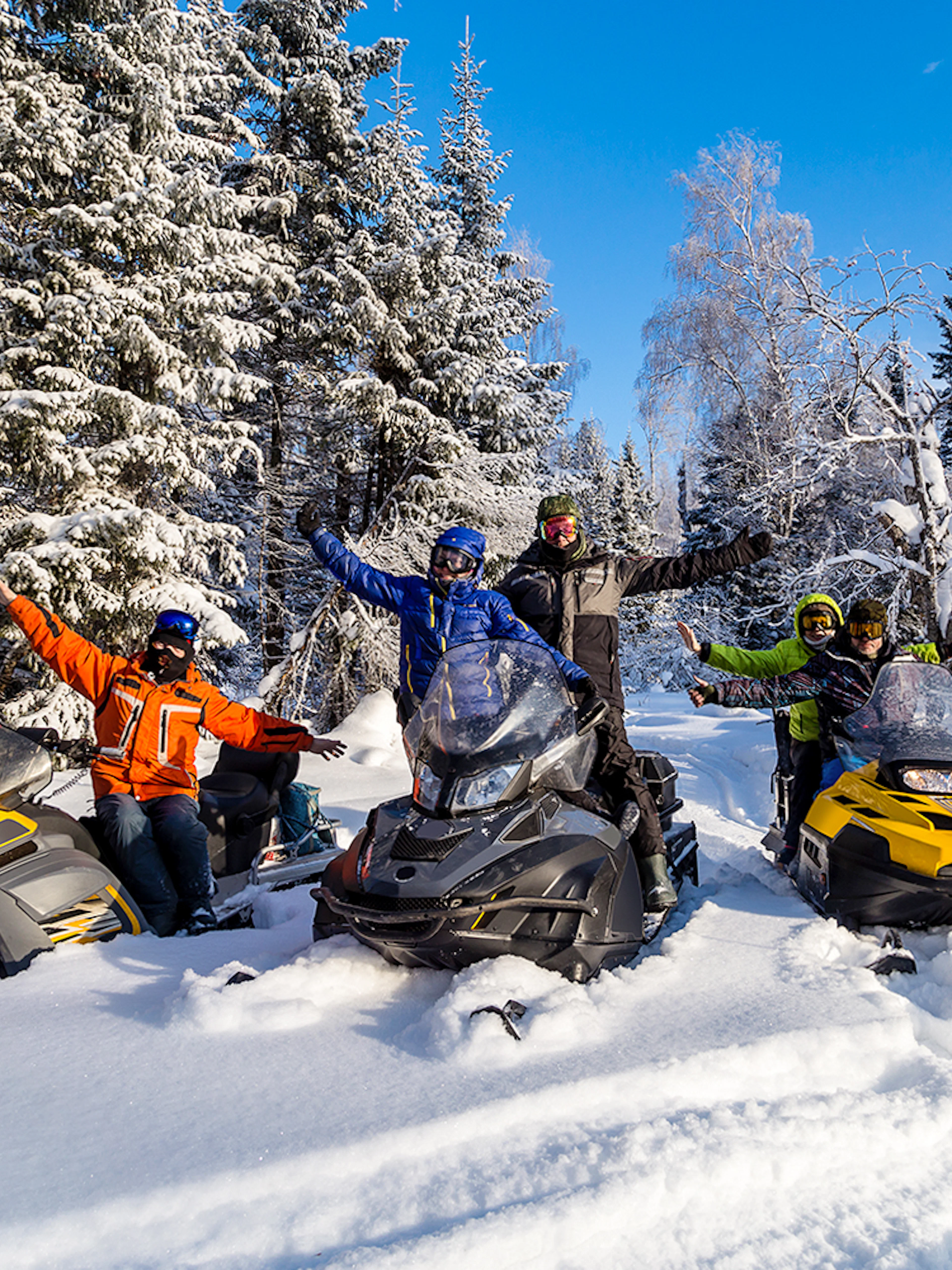 Visitors enjoying snowmobiles in snowy Zakopane forest.