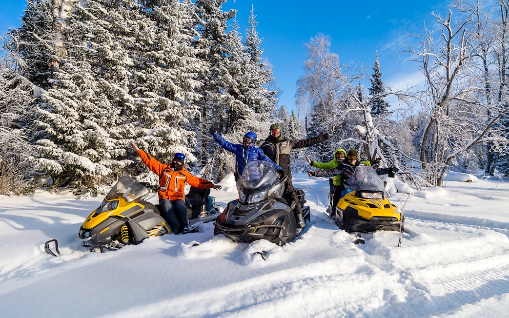 Visitors enjoying snowmobiles in snowy Zakopane forest.