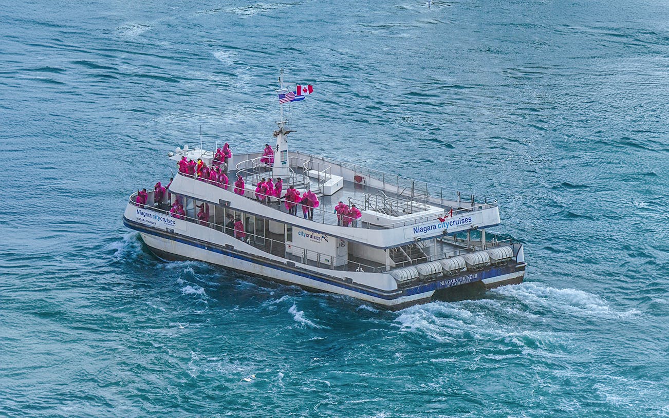 Tourists in pink ponchos on a Niagara City Cruises boat near Niagara Falls, Canada.