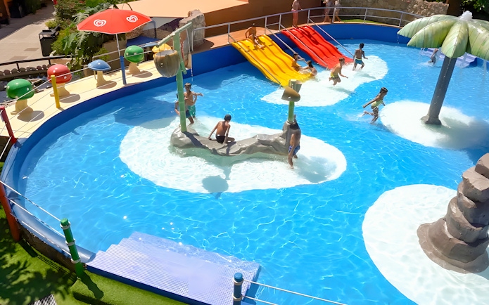 Family enjoying water slides at Marineland Mallorca pool house.