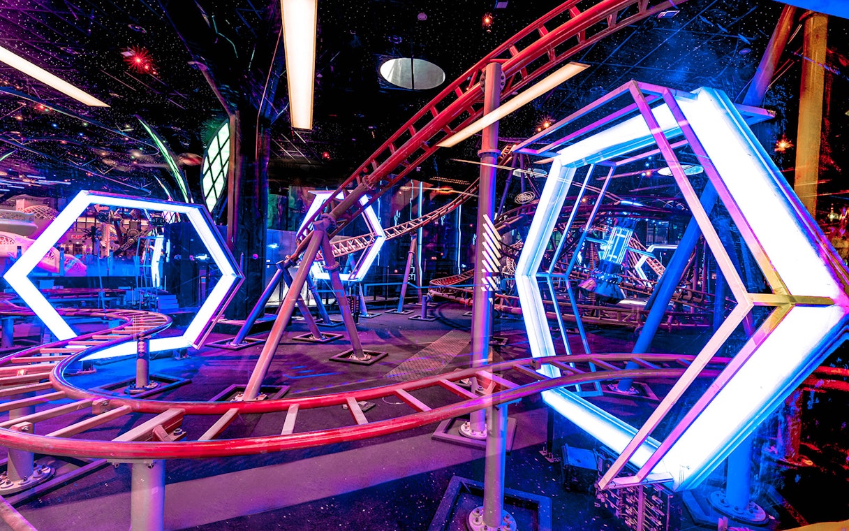 Roller coaster track with neon lights at Doha Quest Theme Park.