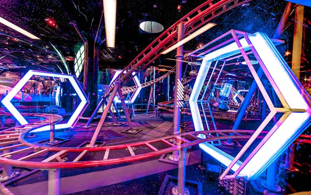 Doha Quest Theme Park indoor roller coaster with vibrant lights and futuristic design.