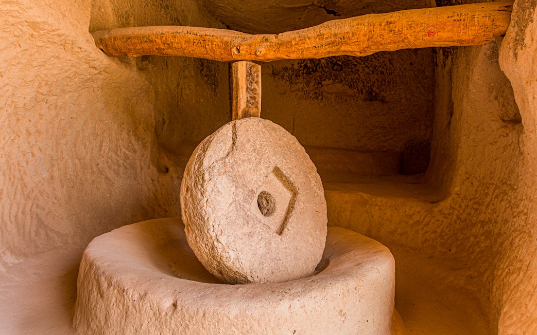 Old stone mill inside rock dwelling in Zelve, Cappadocia, Turkey.